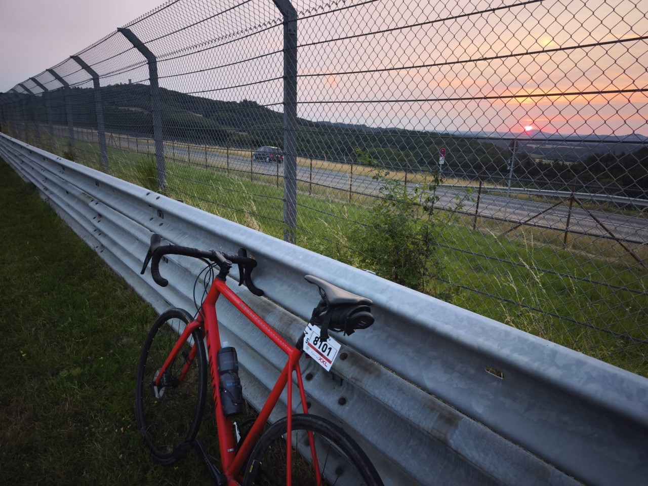 Fahrrad lehnt an die Strckenbegrenzung der Nordschleife bei Sonnenuntergang